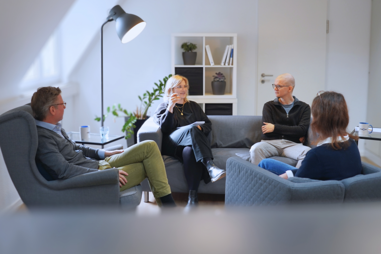 Vier Kolleginnen und Kollegen in einer Besprechung.