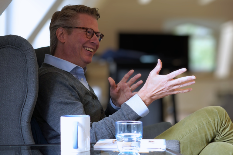 Ein Mitarbeiter führt lachend eine Besprechung.